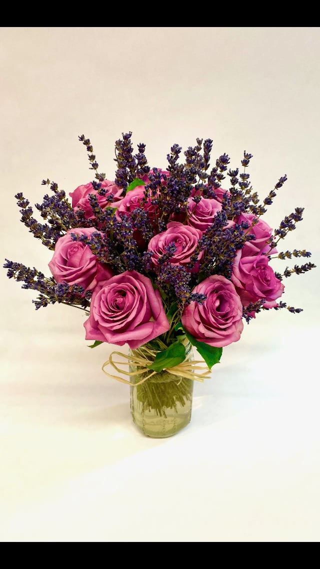 Pink roses with purple filler flowers in a glass vase