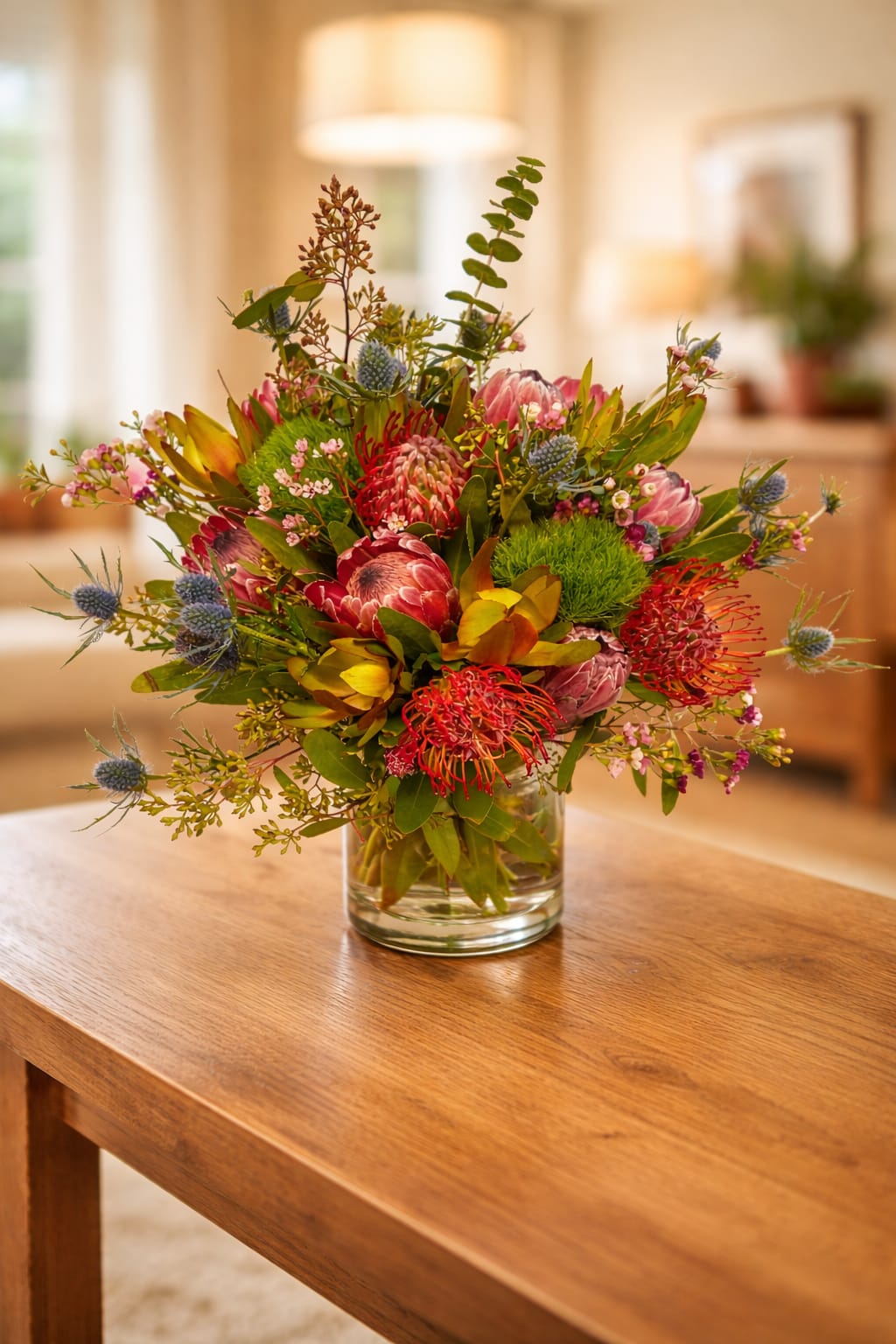 Mixed bouquet of pink and red flowers in a clear glass vase