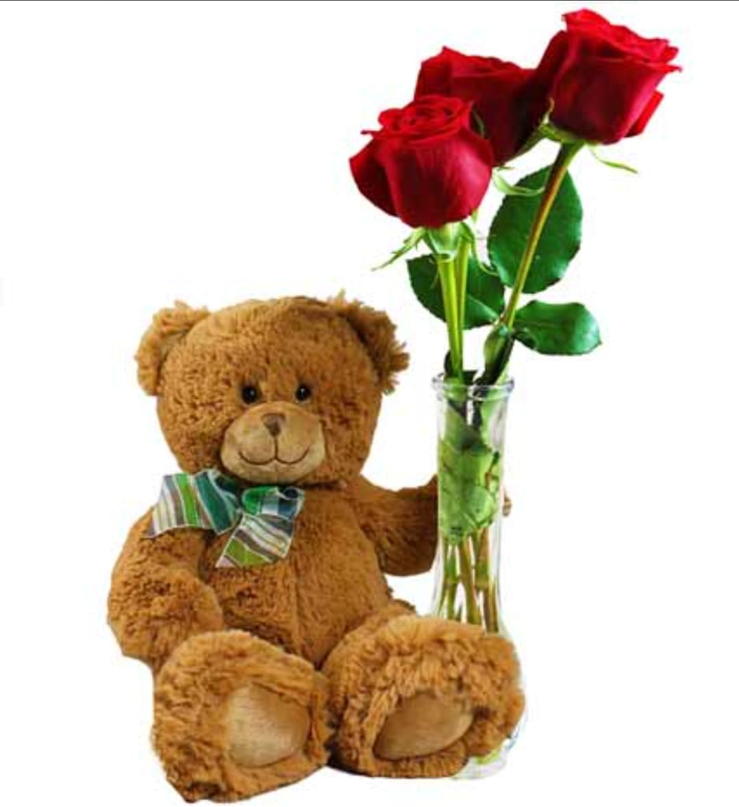 Teddy bear beside a glass vase with three red roses