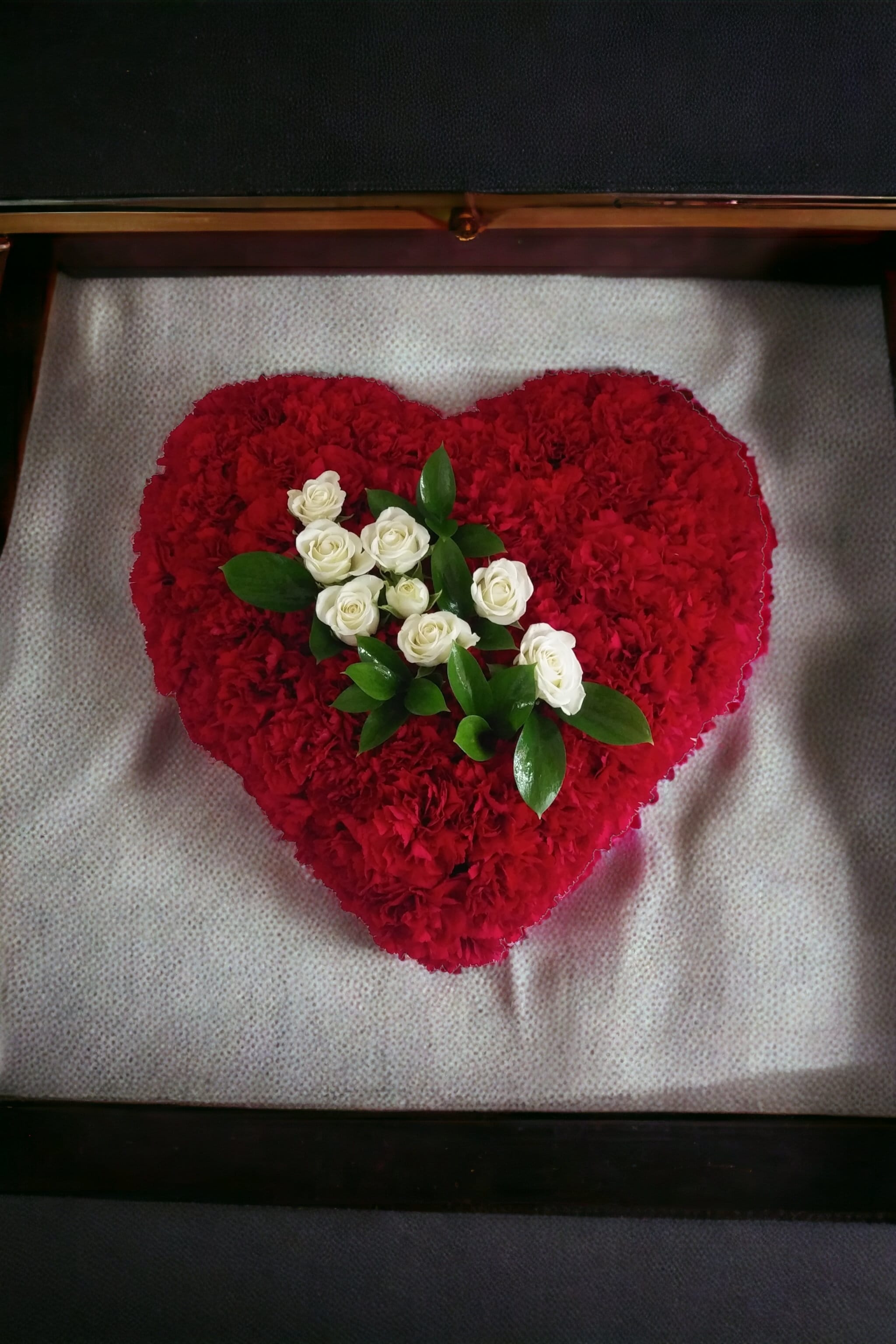 Heart-shaped red floral arrangement with white roses in the center