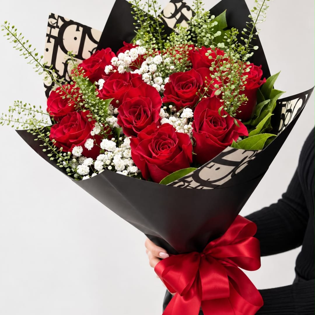Bouquet of red roses with white baby's breath in black wrap and a red ribbon
