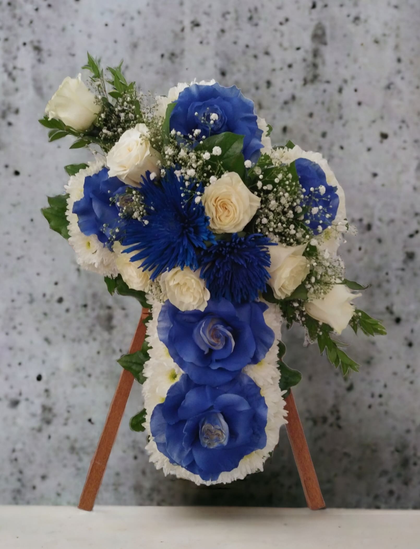 Blue and white floral arrangement on a wooden easel