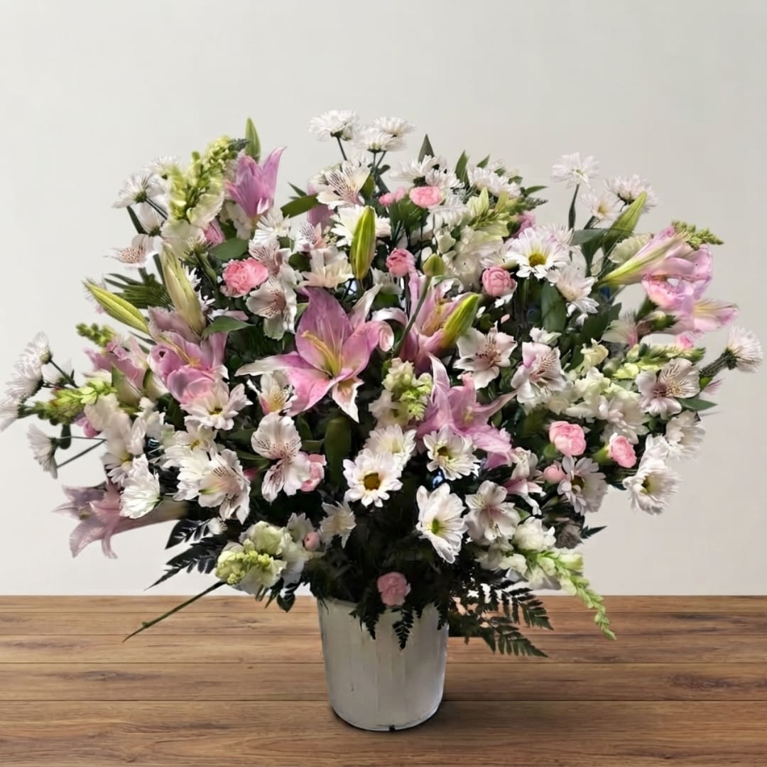 Large pink and white mixed flower arrangement in a white vase