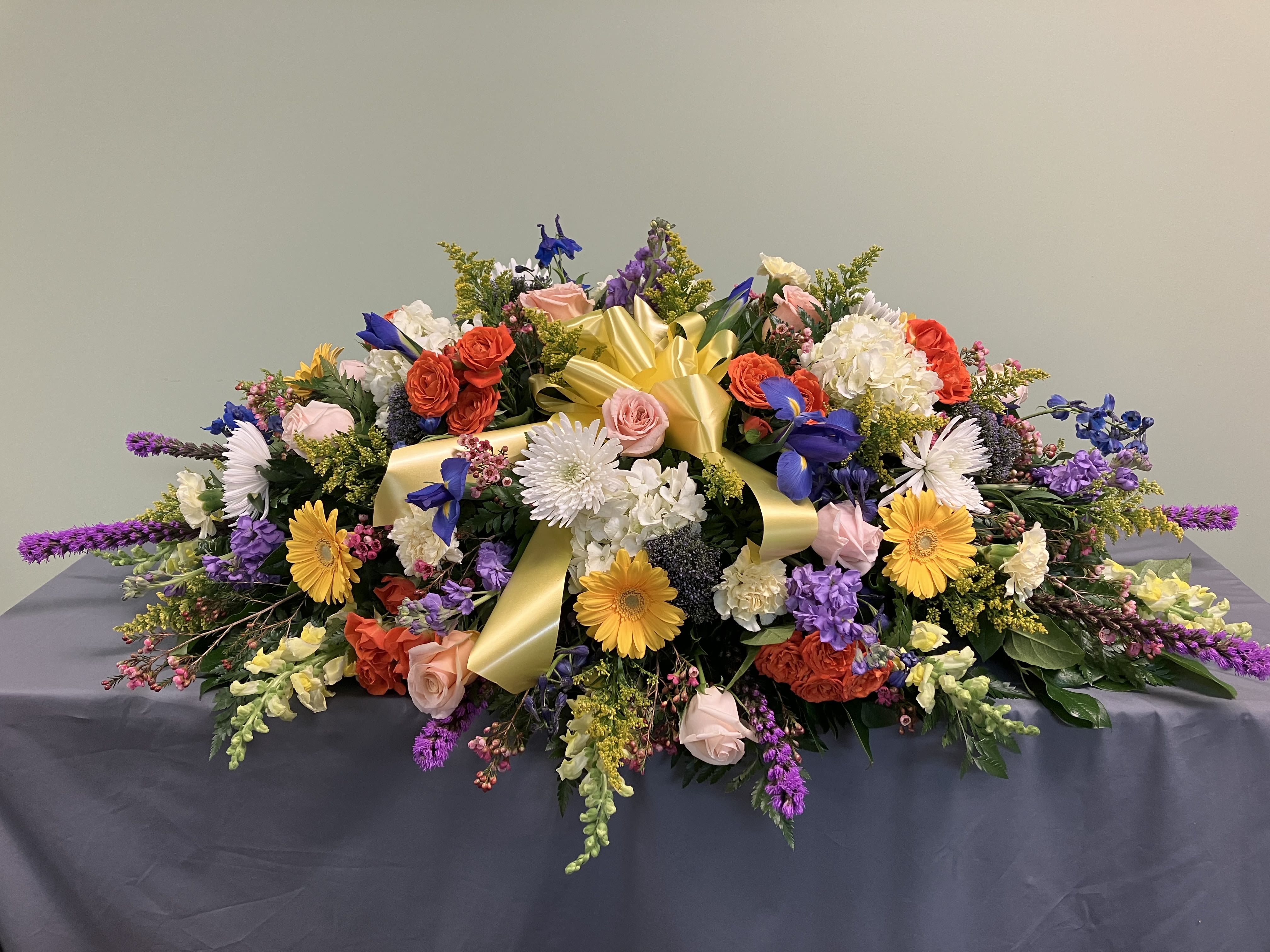 Large mixed floral arrangement with a yellow ribbon bow
