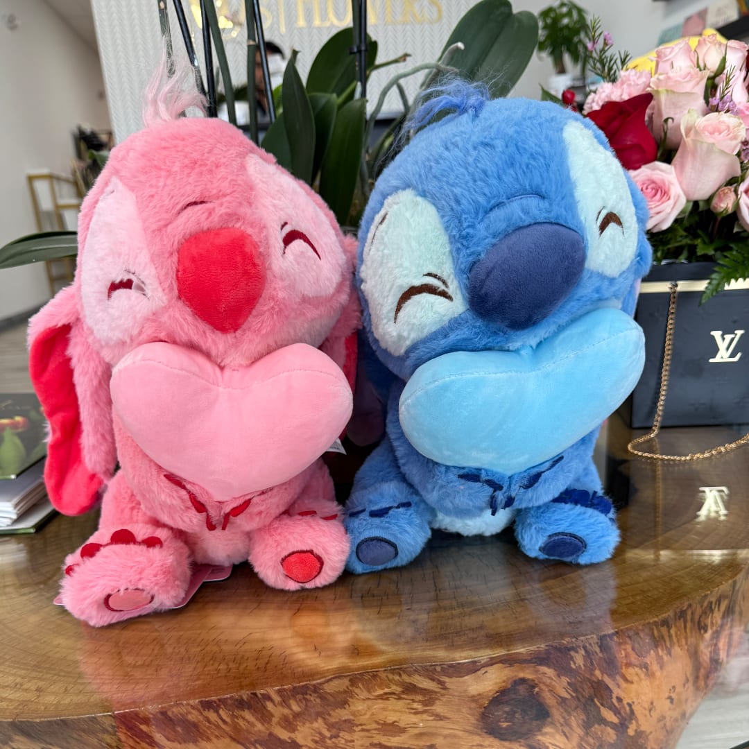 Two plush cartoon animals holding hearts, with roses in the background