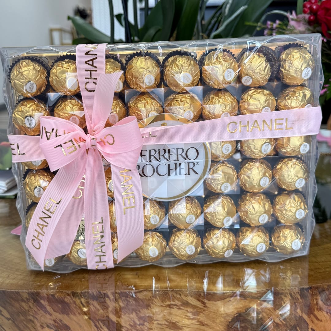 Box of Ferrero Rocher chocolates wrapped with pink Chanel ribbon and bow