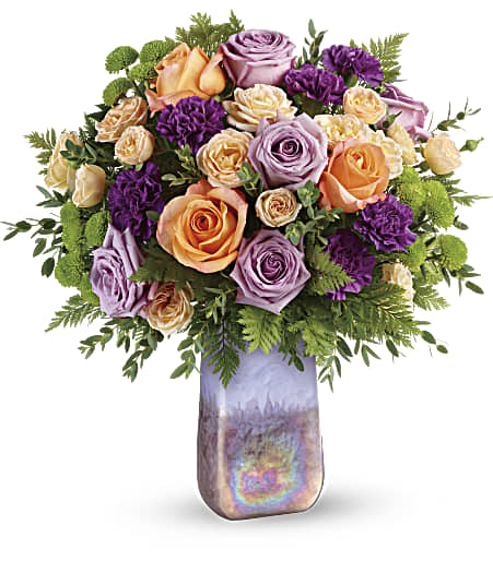 Bouquet of peach, lavender, and purple roses in a tall iridescent vase