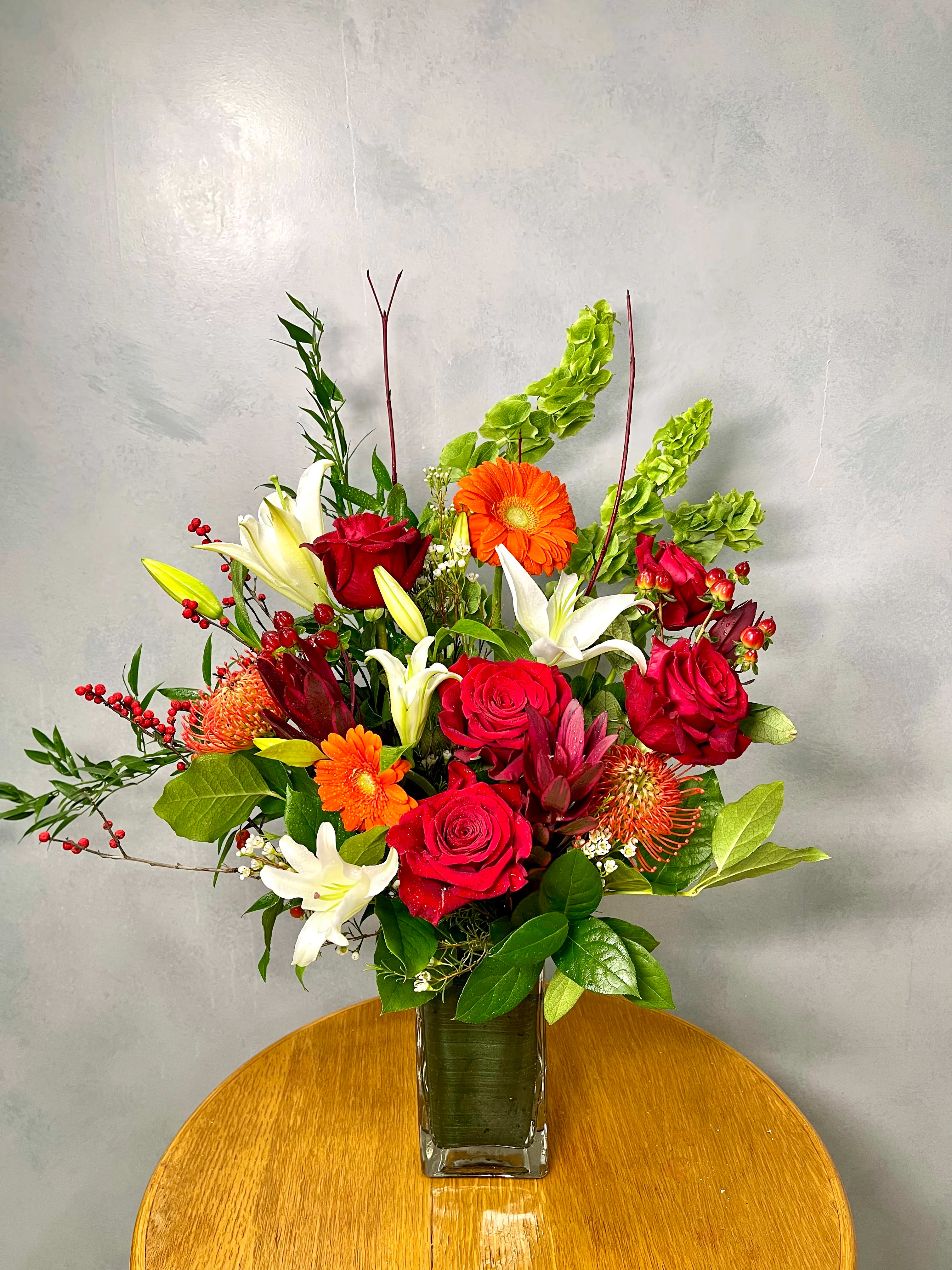 Blooming Fantasia - Ring in the holidays with this seasonal treasure of asiatic lilies, ginger, roses, and bells of Ireland