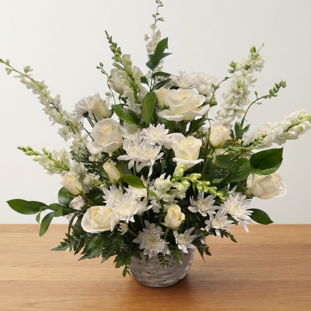 White roses and daisies arranged in a gray basket vase