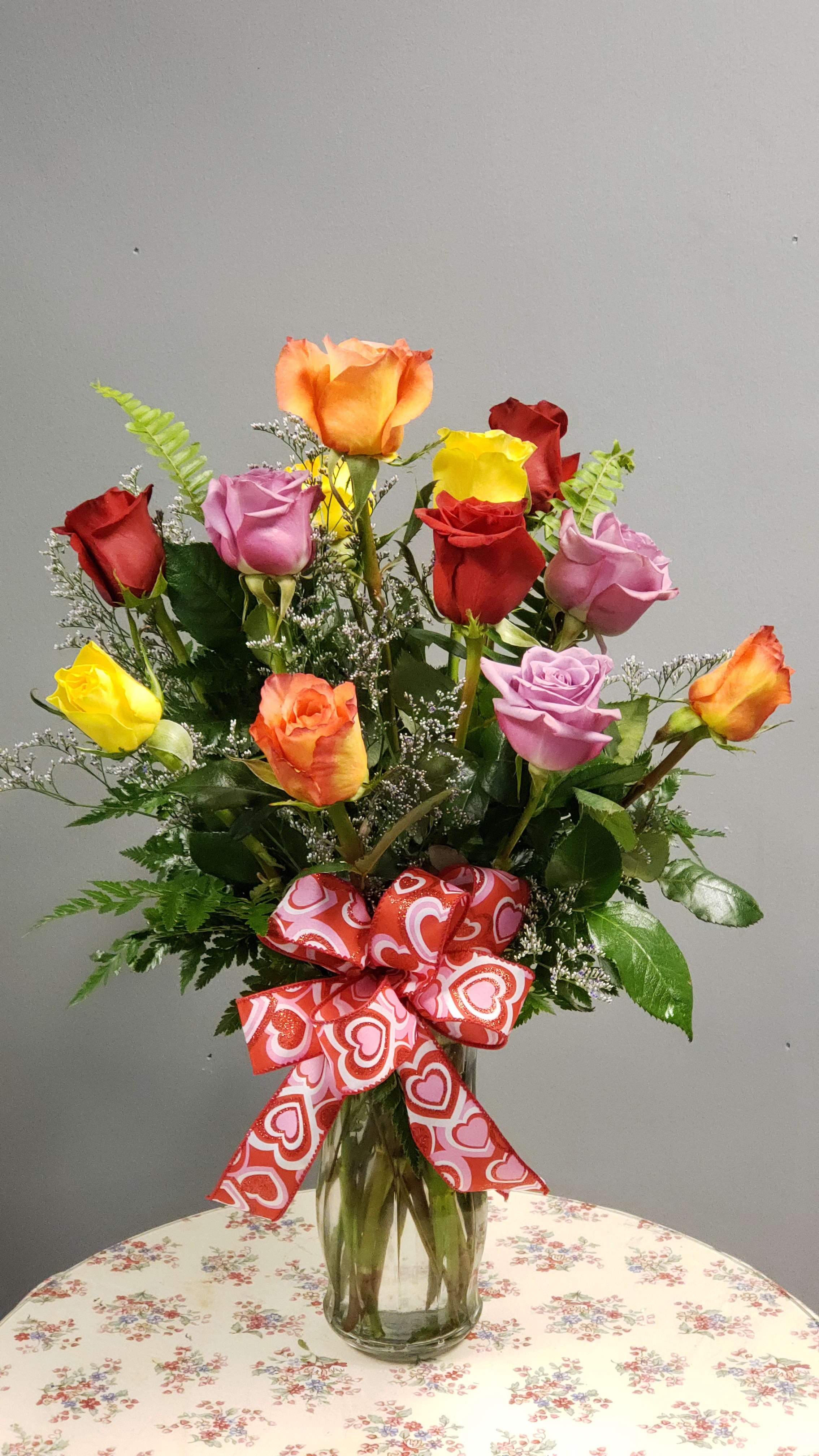 Colorful Dozen  - 12 premium roses vased with eucalyptus, fern, salal leaves and babies breath.  Actual rose color may differ based on availability. 