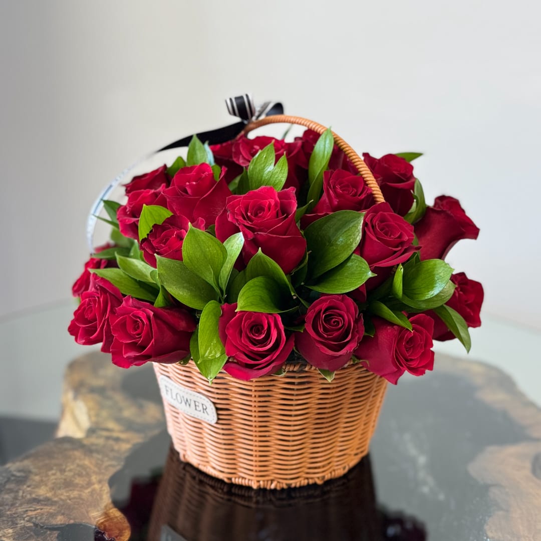 Basket of red roses with green foliage