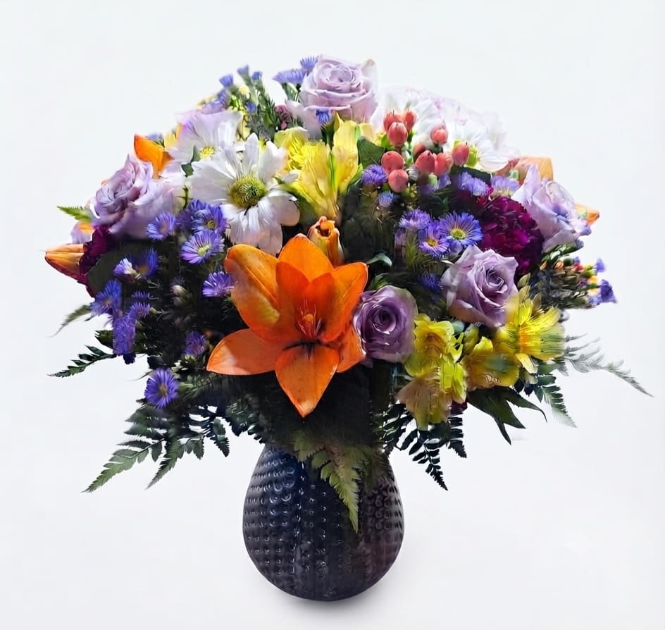 Mixed bouquet of colorful flowers in a dark textured vase