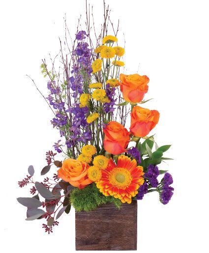 Tall floral arrangement with orange roses, yellow daisies, and purple blooms in a wooden box