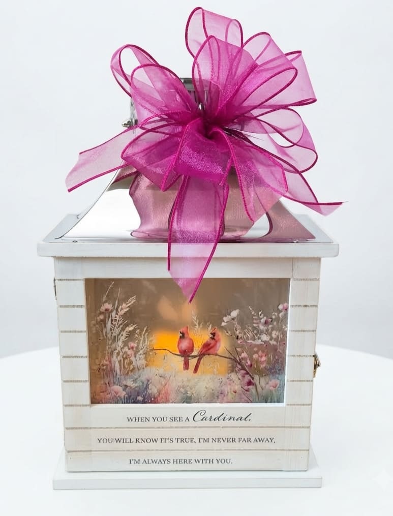 Decorative white lantern with a large pink bow and cardinal artwork