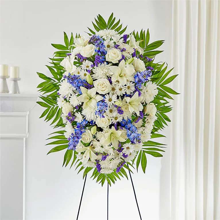Standing floral spray of white and blue flowers on an easel