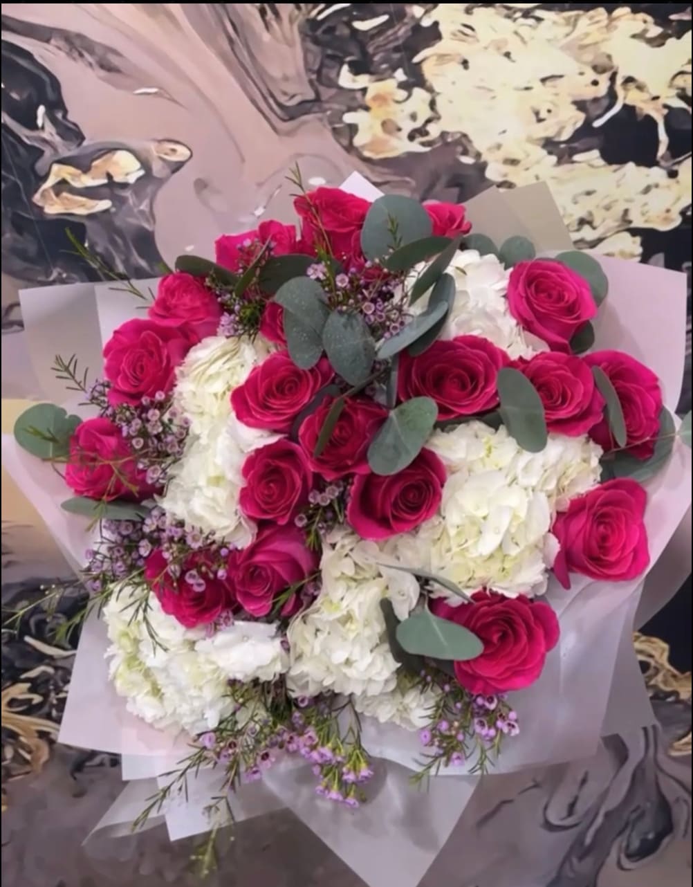 Bouquet of hot pink roses and white hydrangeas with eucalyptus