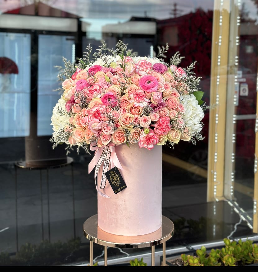 Large pink and white rose arrangement in a tall blush box
