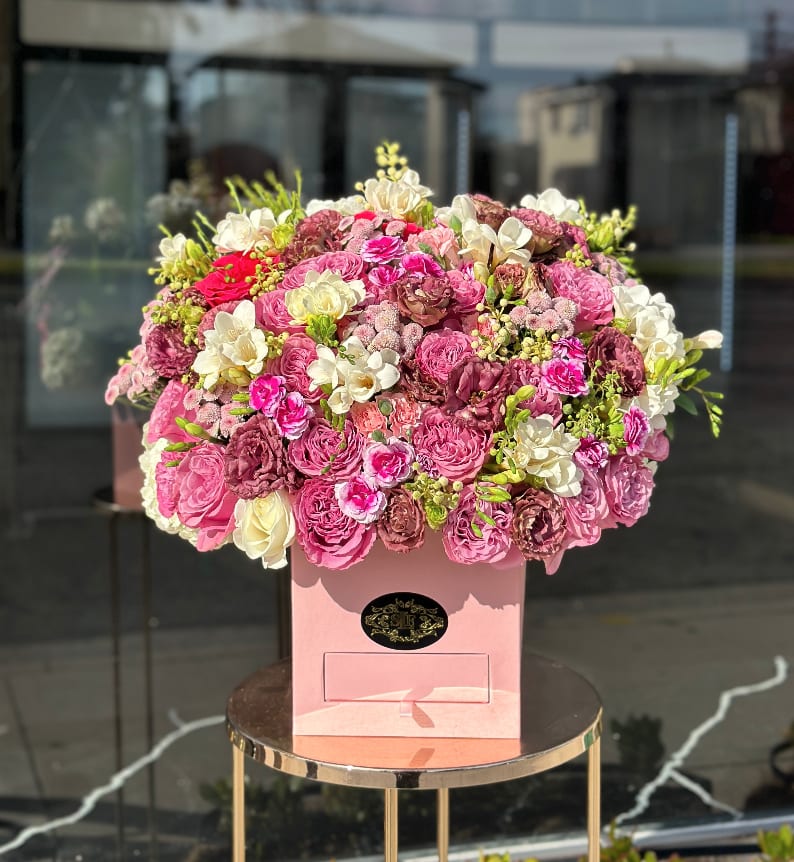 Large pink and white rose arrangement in a pink box
