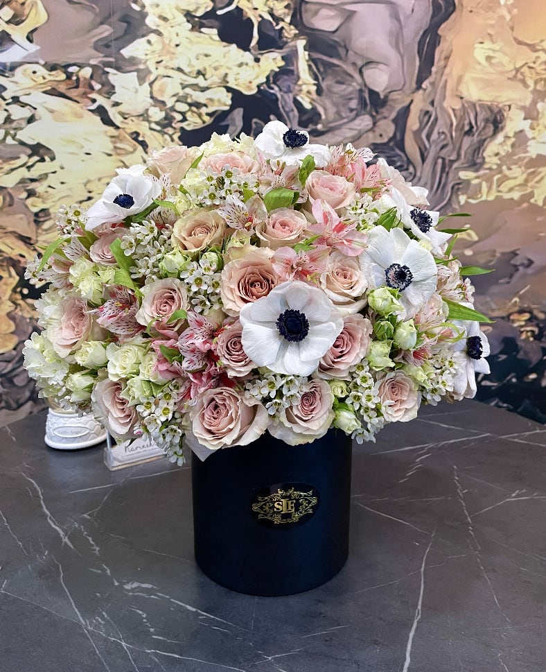 Large bouquet of blush roses and white anemones in a black hat box
