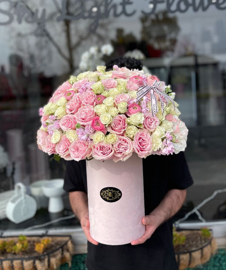 Large pink and cream rose arrangement in a tall round box