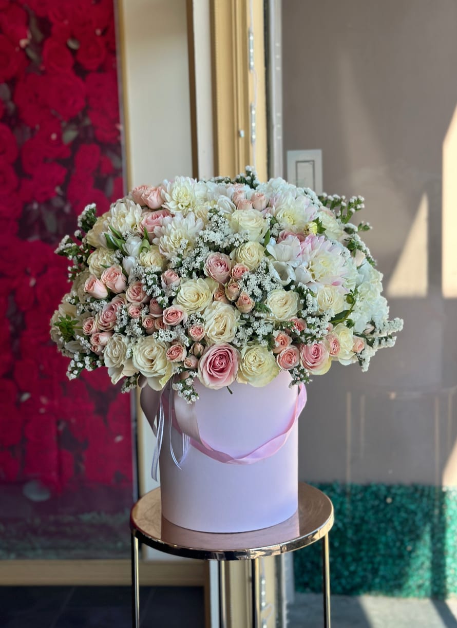 Large bouquet of pink and white roses in a round box