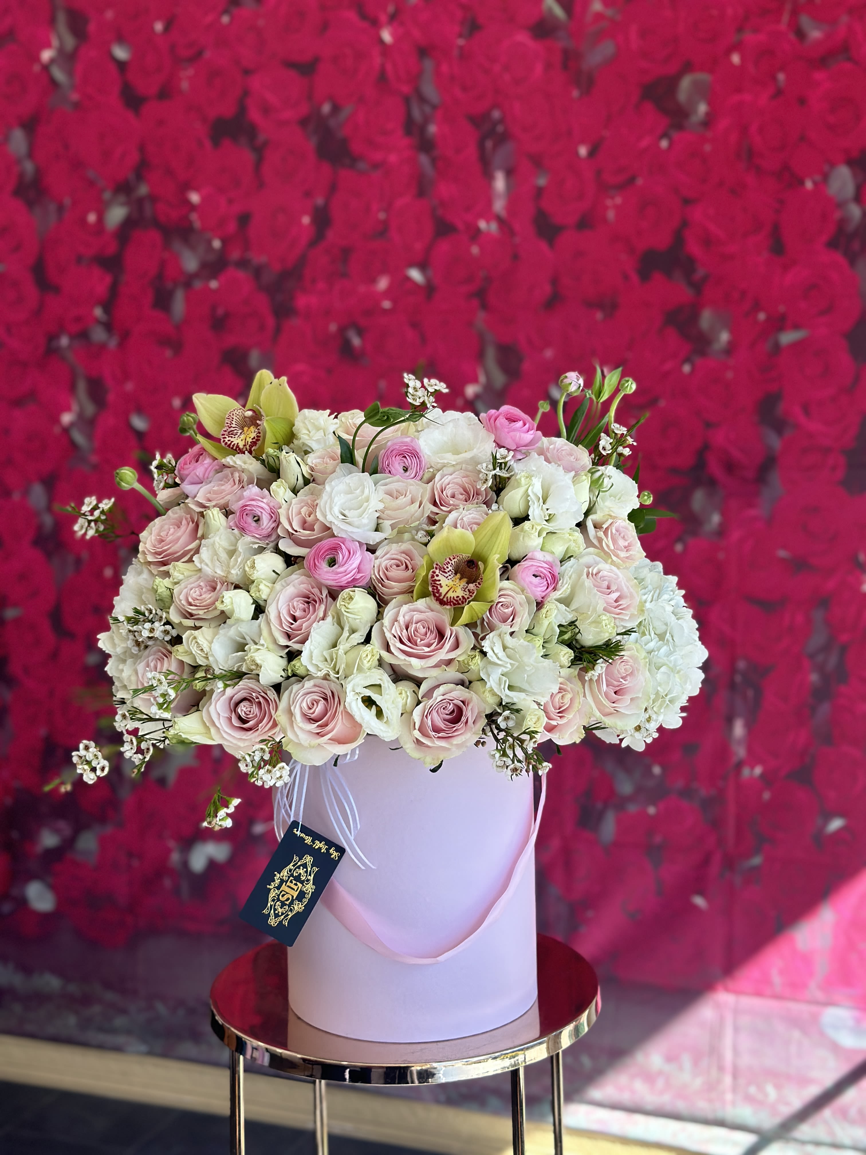 Large bouquet of pink and white roses in a pale pink hat box