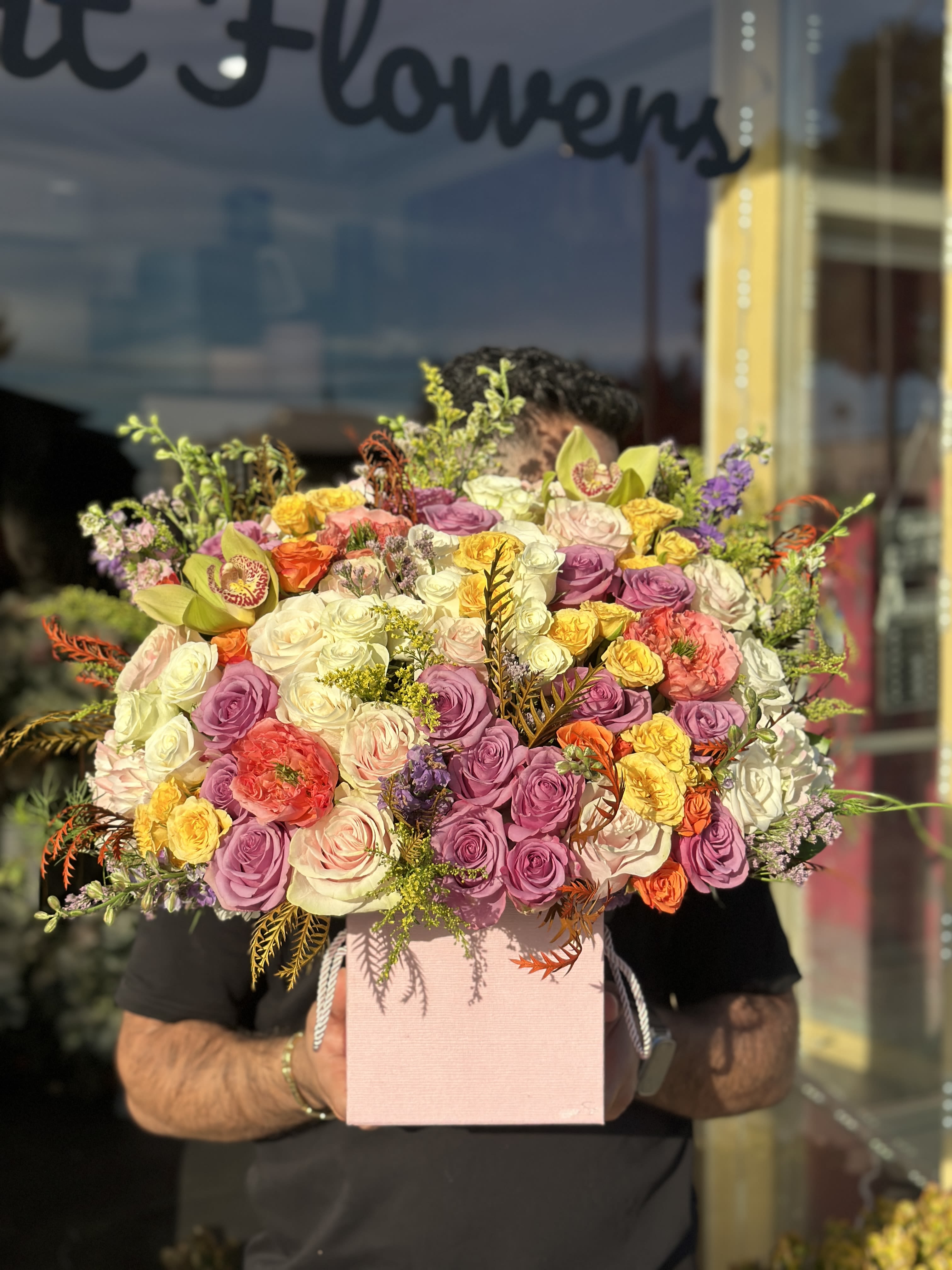 Large mixed bouquet of roses in a pink box