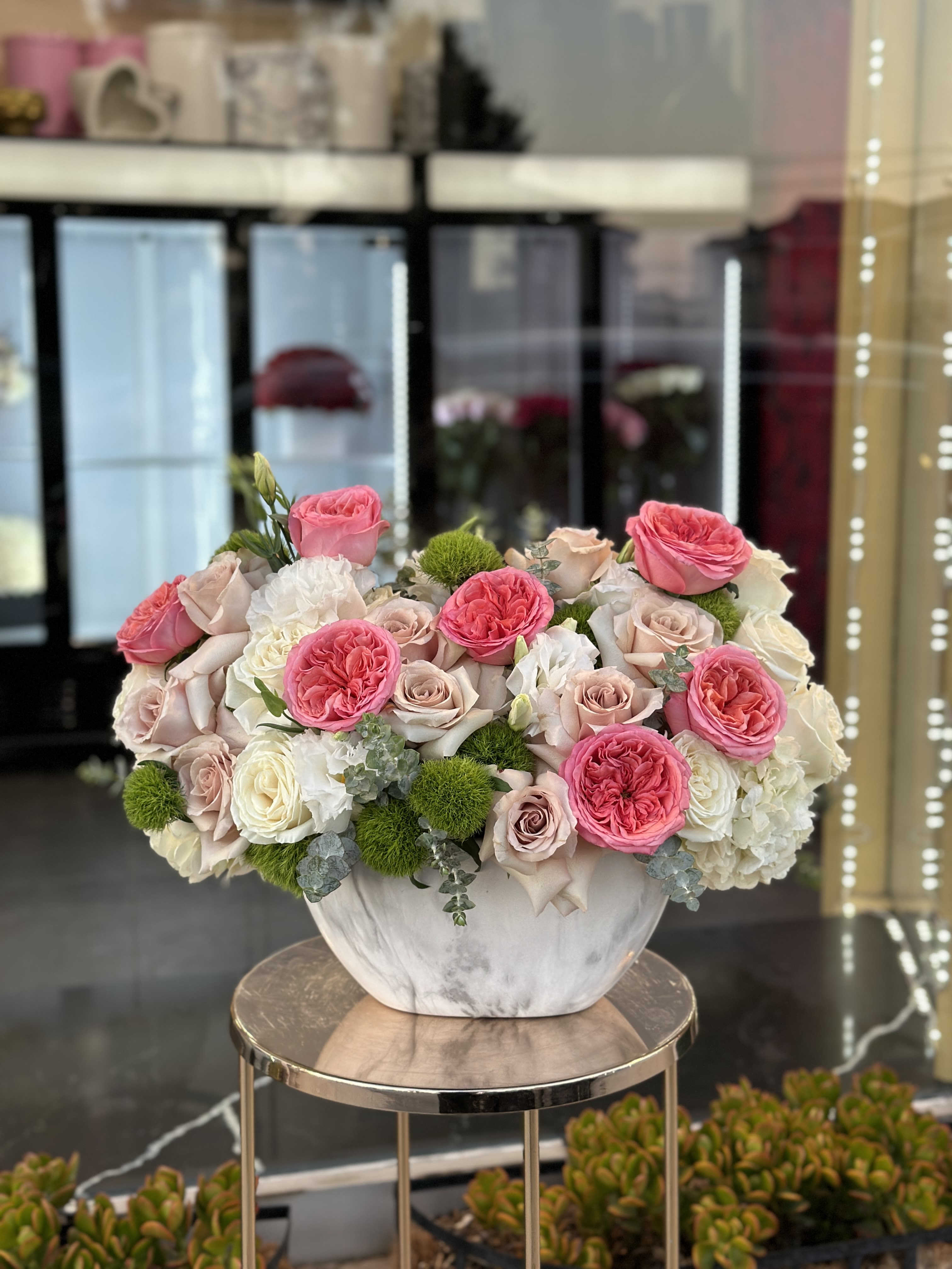 Pink and white roses arranged in a white vase