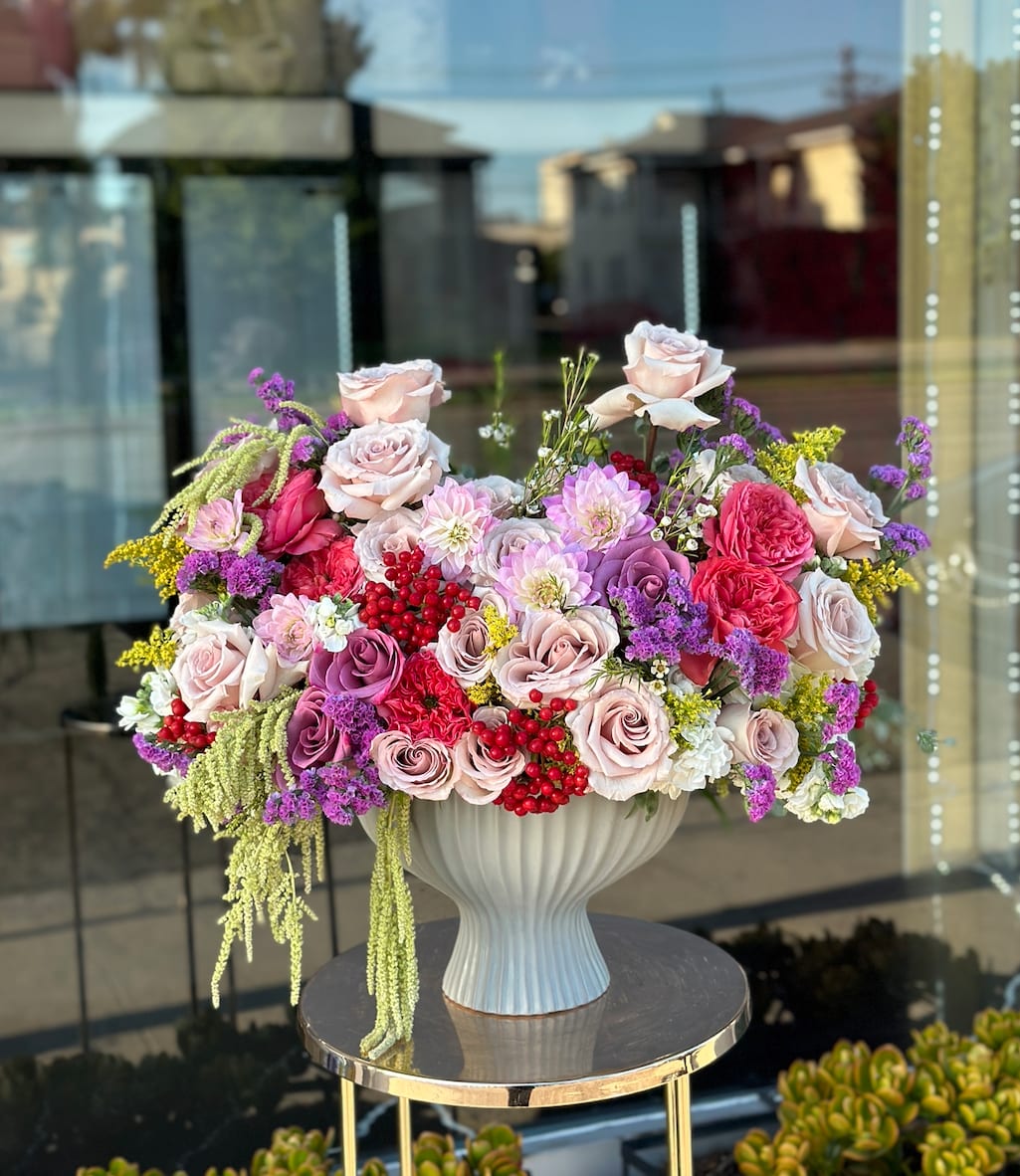 Large mixed bouquet of pink and purple roses in a white vase