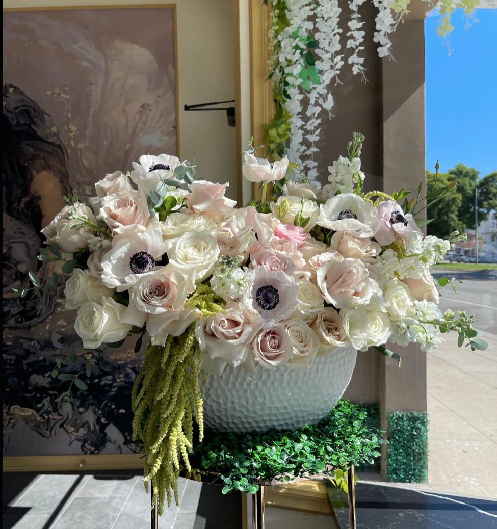 Large white and blush floral arrangement in a textured bowl vase