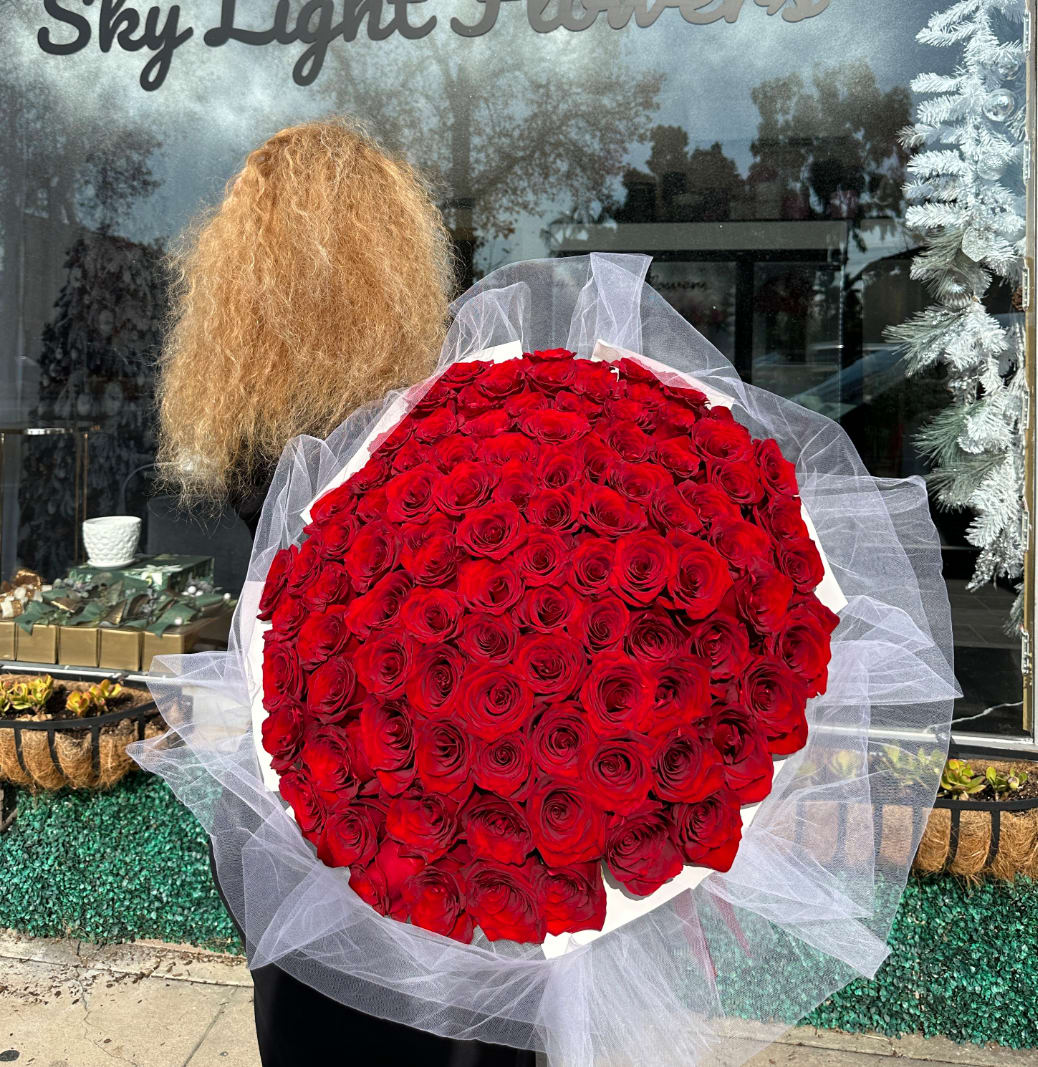 Large bouquet of red roses wrapped in white tulle