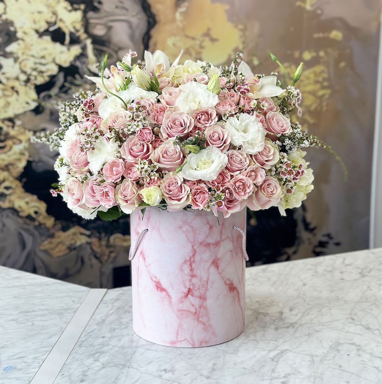 Pink and white rose arrangement in a pink marbled hatbox