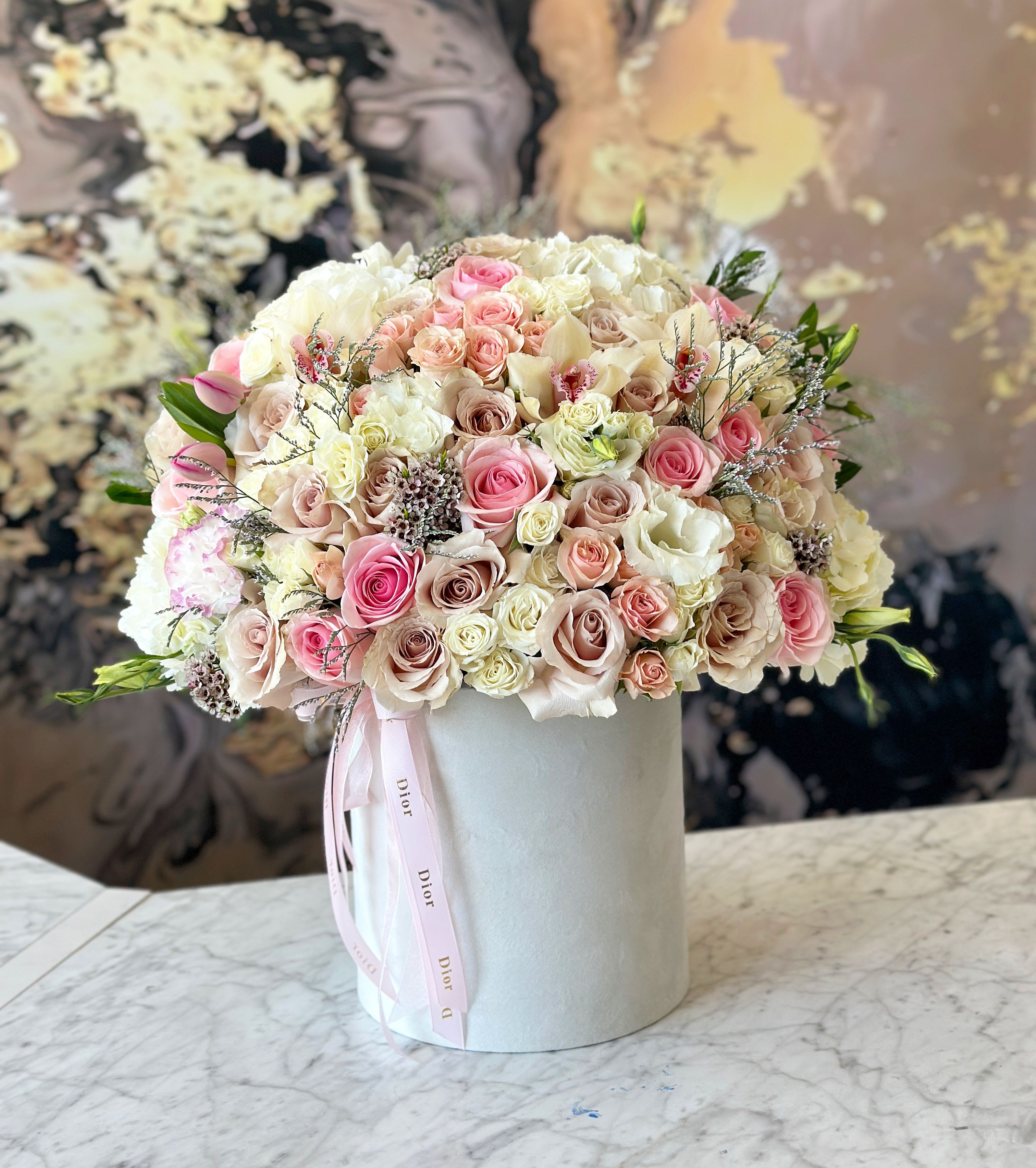 Round bouquet of pink and white roses in a white hat box