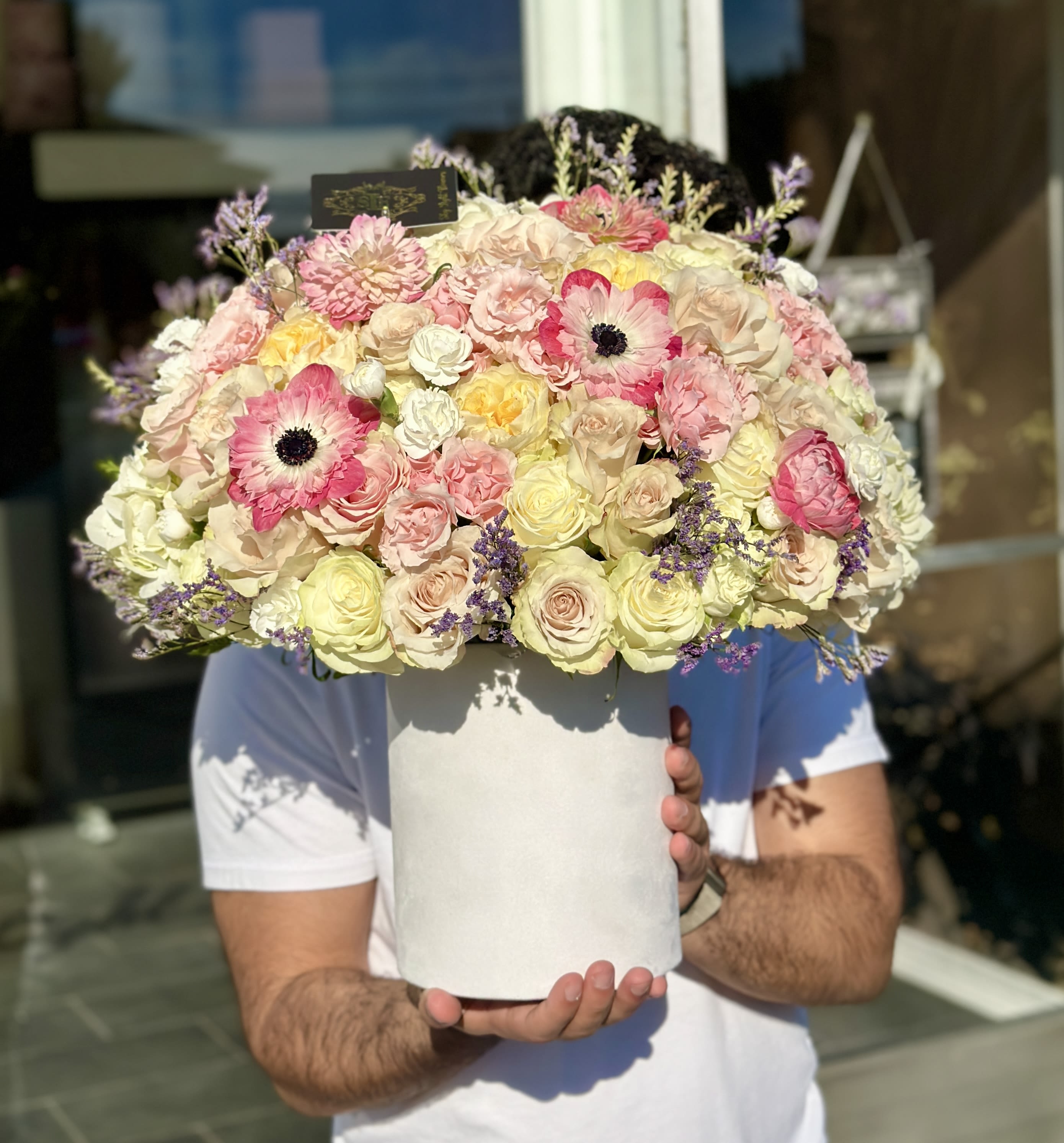 Large pastel bouquet of roses and pink anemones in a white hat box