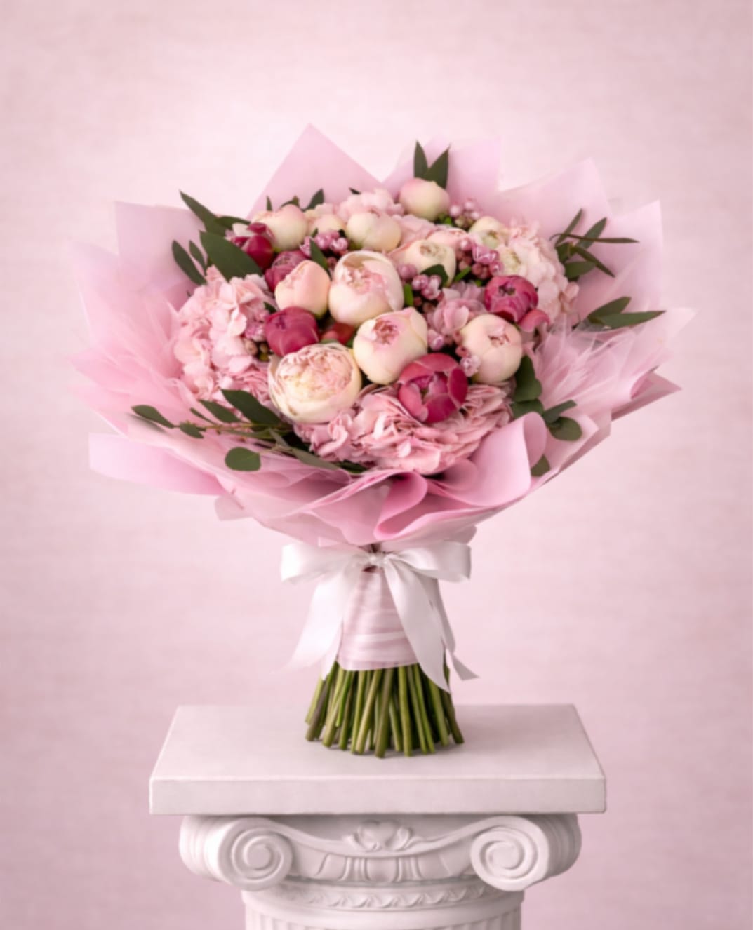 Pink bouquet of peonies and hydrangeas wrapped in pastel paper