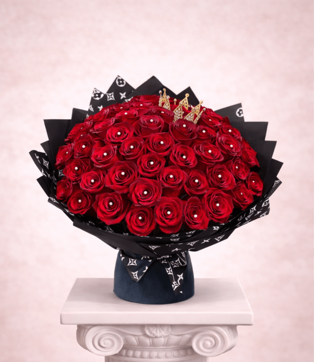 Large bouquet of red roses in black wrapping with gold crown accents