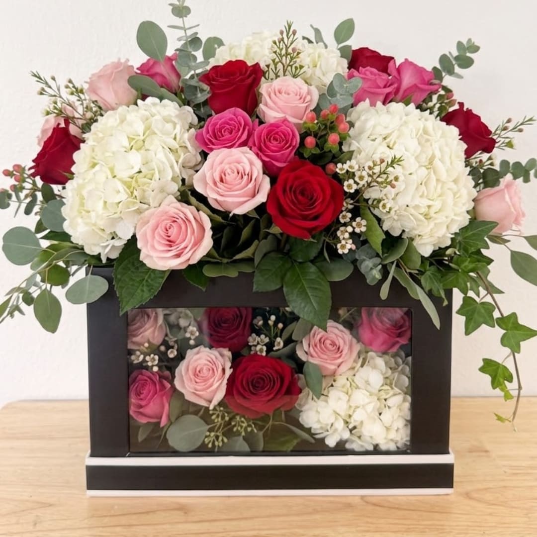 Pink and red roses with white hydrangeas in a black box arrangement