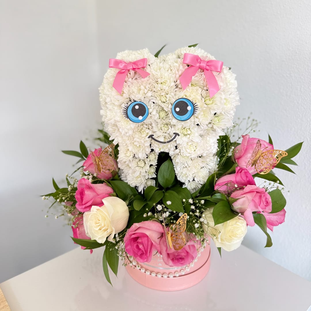 Heart-shaped white flower arrangement with pink bows and roses in a pink box