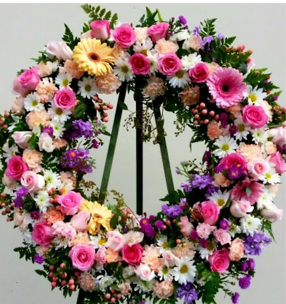 Large floral wreath with pink roses, daisies, and purple flowers