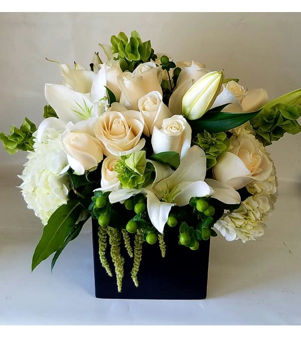 White and cream bouquet in a black square vase