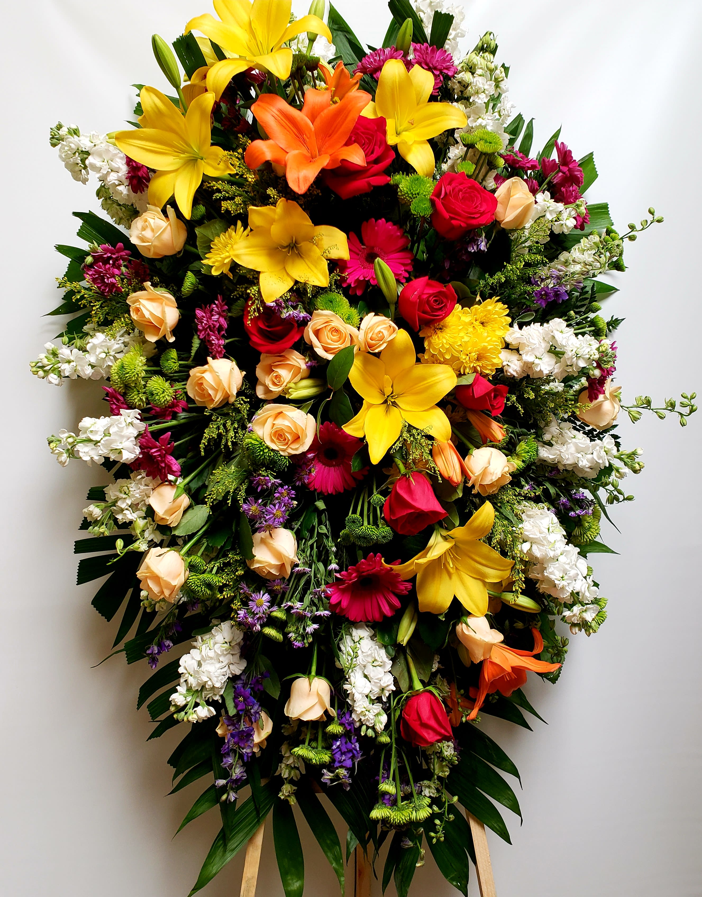 Large standing spray of mixed colorful flowers on an easel