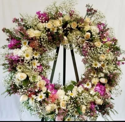Large floral wreath with cream and pink flowers on a stand