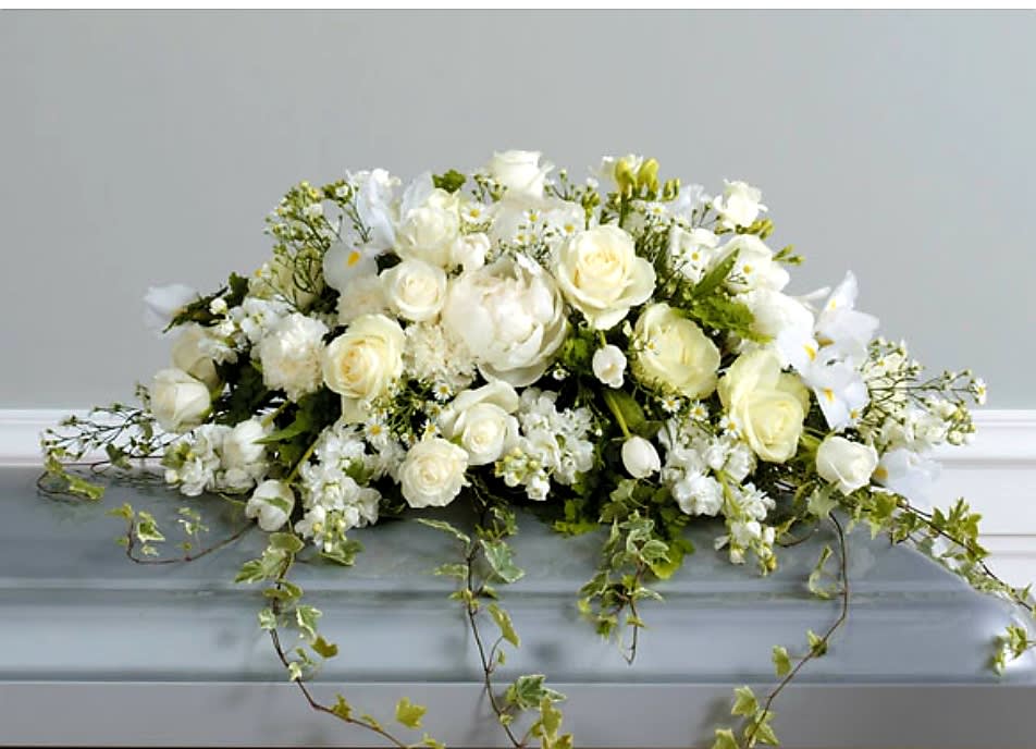 Loving Memories Casket Spray - A pure white, loving tribute created with roses, iris, tulips, carnations and tenderly trailing ivy.