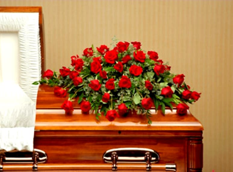 Red Rose Casket Spray - An abundance of red roses will express your love and devotion with beauty. This classic casket spray of roses mixed with greenery will be a fragrant reminder on a solemn day.
