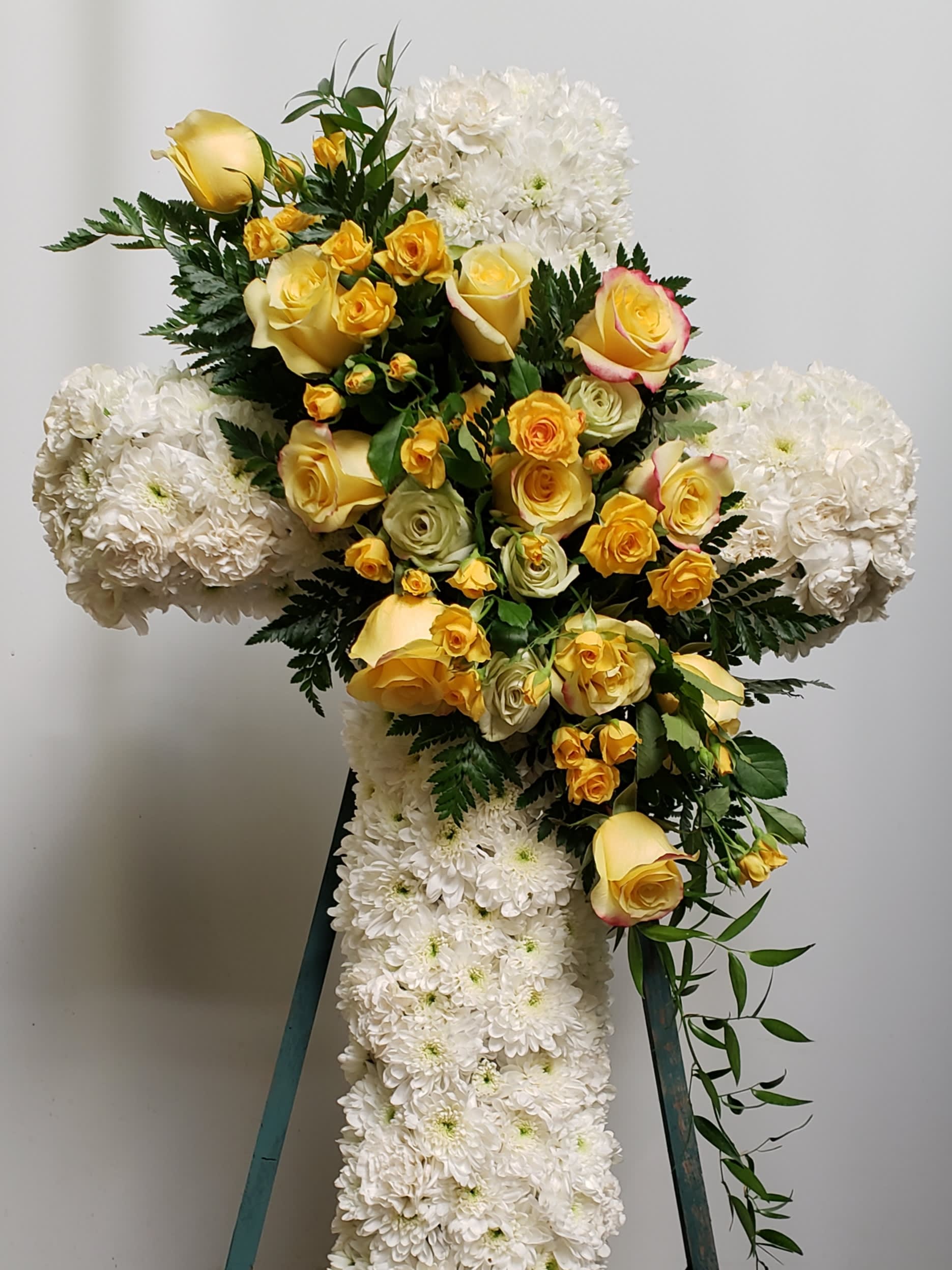 Cross-shaped floral spray with yellow roses and white chrysanthemums