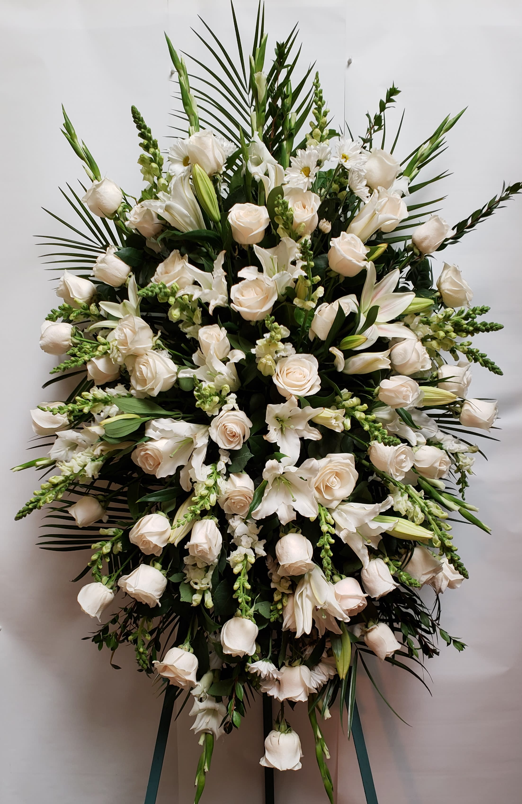Large white floral standing spray with roses and lilies