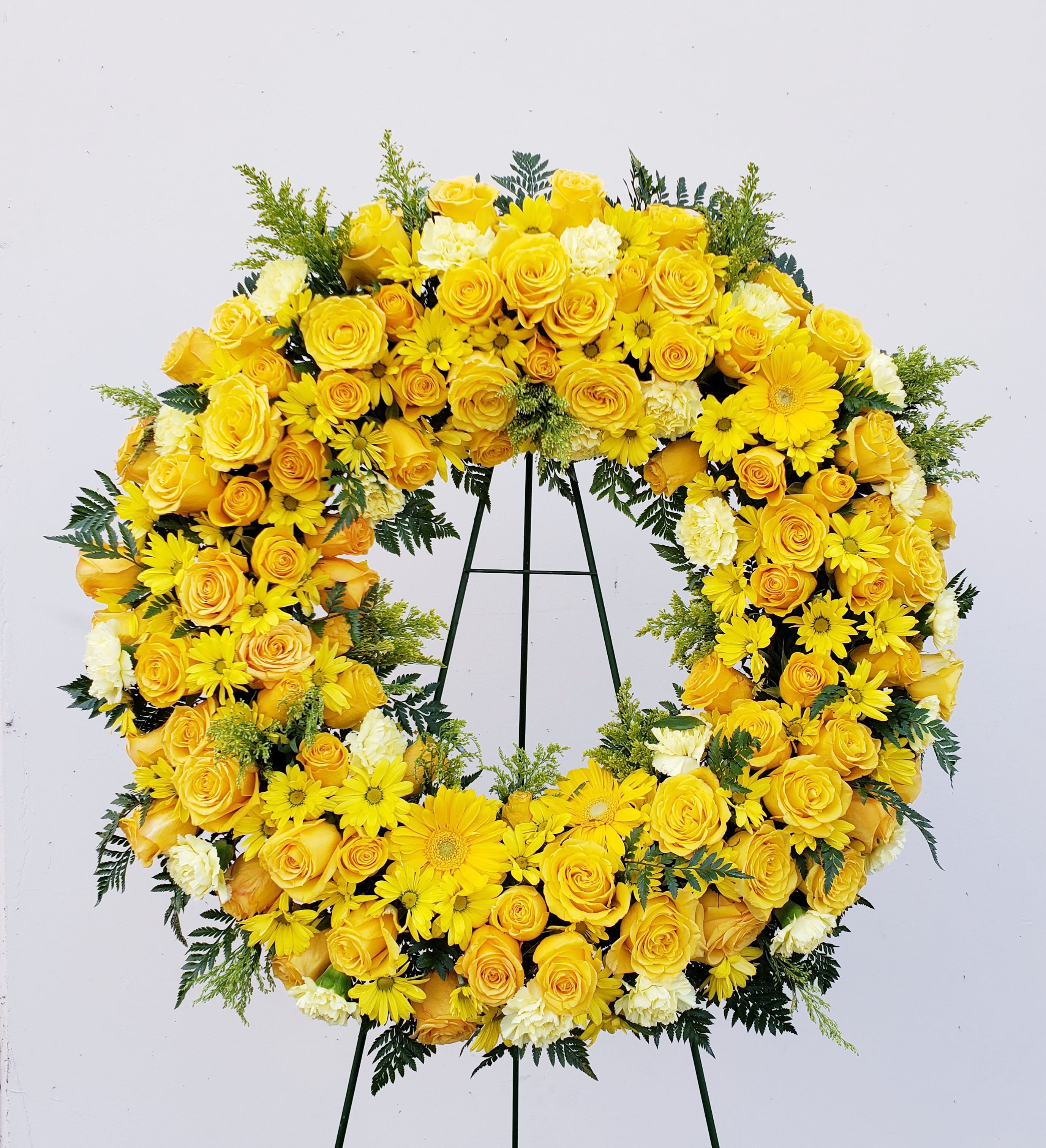 Yellow floral wreath on a black stand