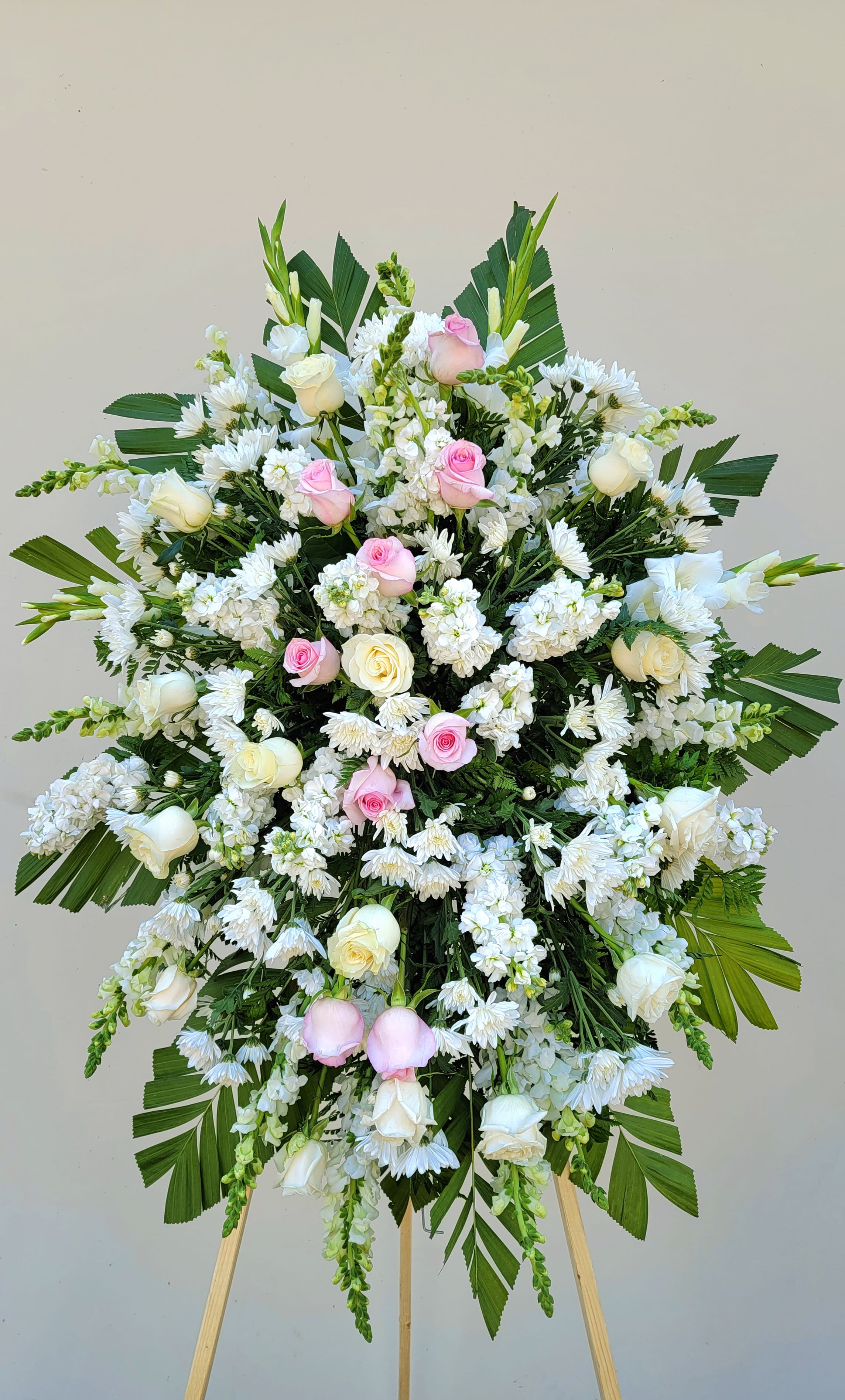 Large standing floral spray with white and pink roses and white daisies