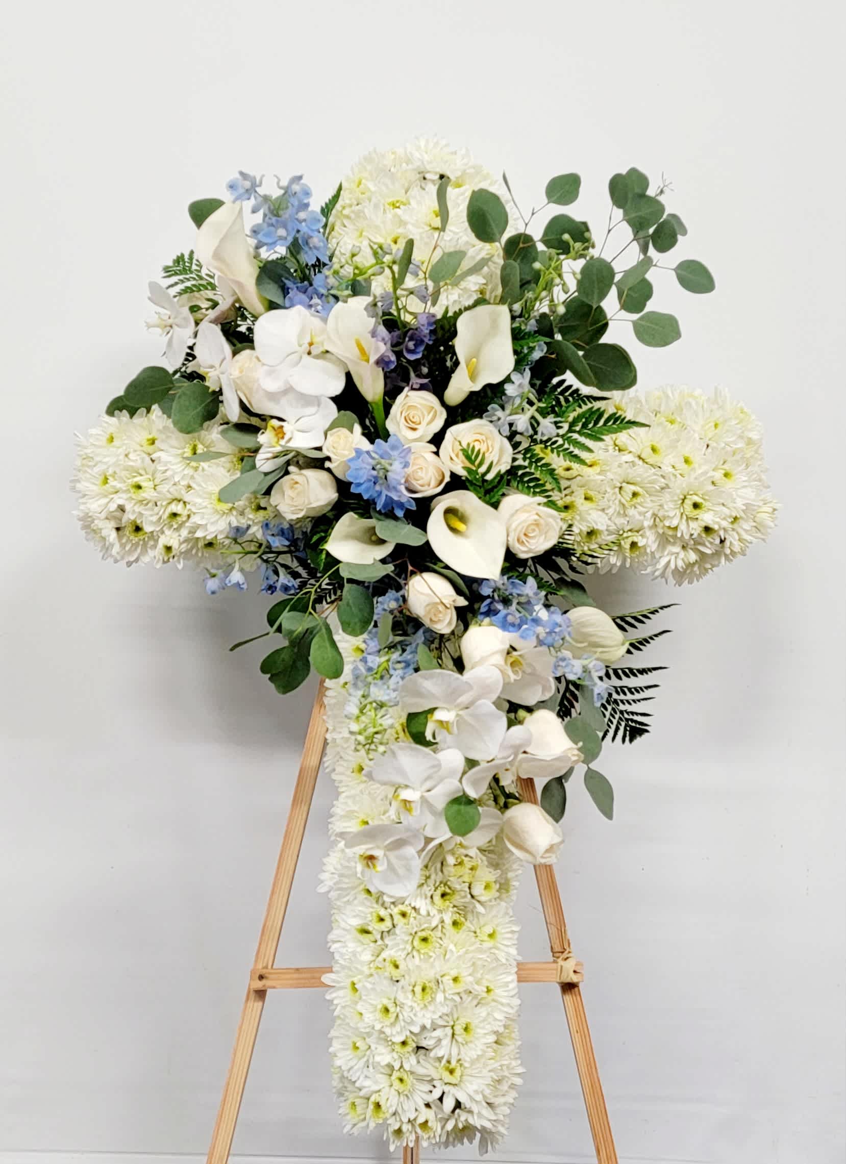 White floral standing spray with orchids, roses, and chrysanthemums