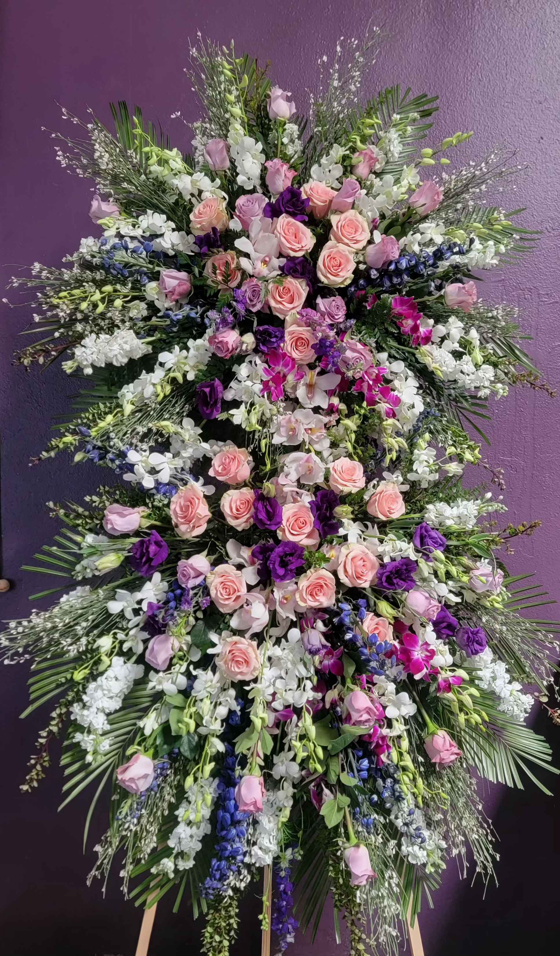 Large standing floral spray with pink and purple roses and orchids